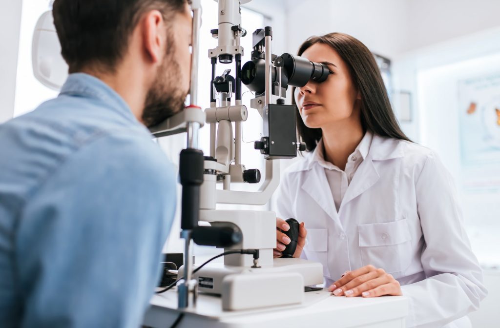 A female optometrist examining a male patient's eyes