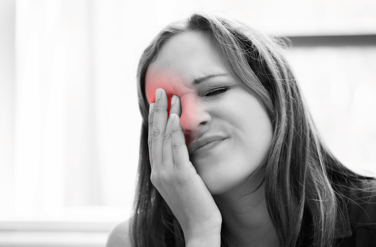 A woman holds her eye in pain due to an infection