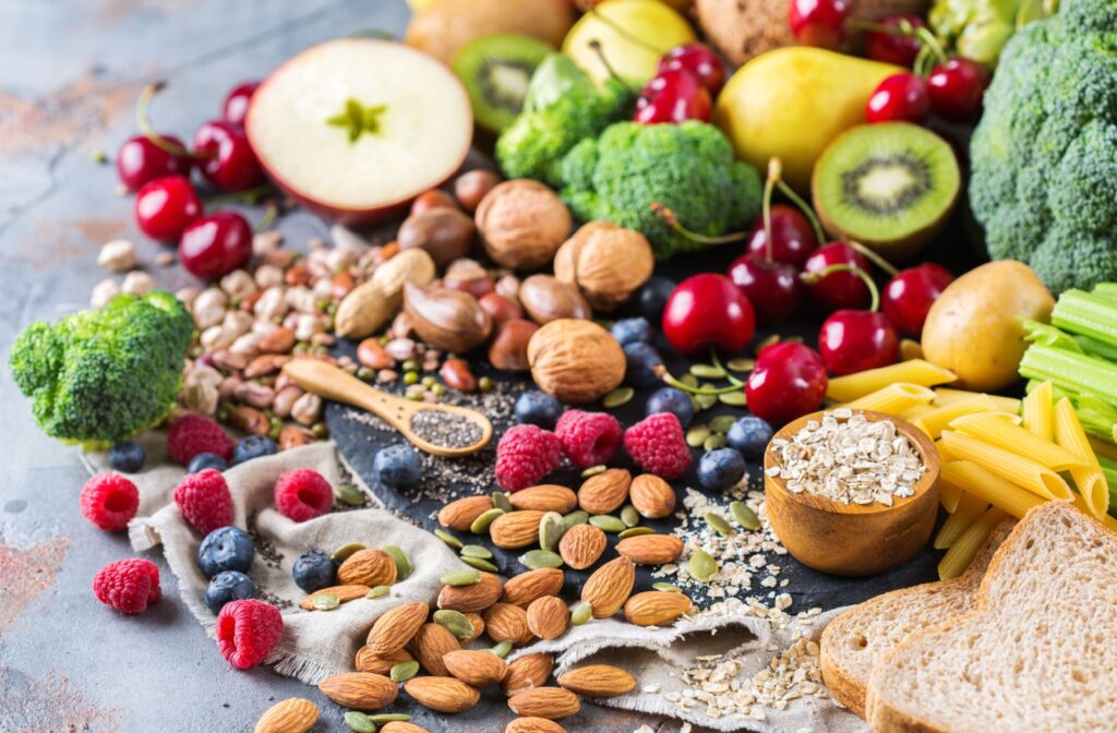 A pile of assorted eye-friendly foods, including nuts, seeds, berries, citrus fruits, vegetables, and more.