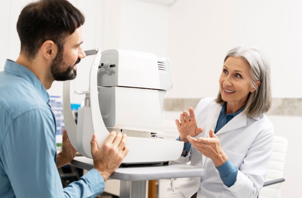 Optometrist explaining eye exam procedure to patient using diagnostic equipment in a modern clinic setting