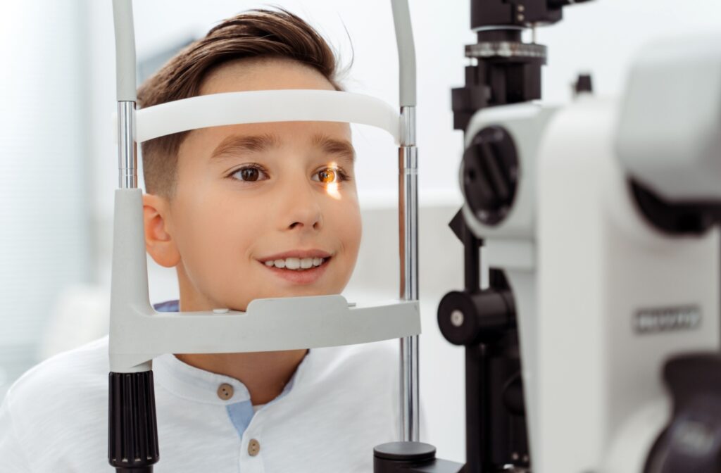 A young boy having his eyes examined with a slit lamp during a comprehensive eye exam.