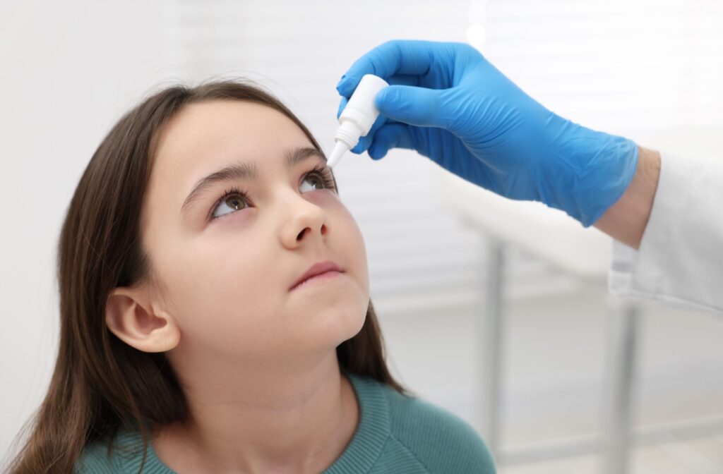 A girl at an optometry office getting atropine eye drop treatment to help slow the progression of myopia.